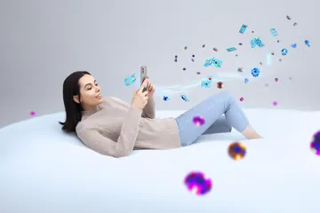 Uma mulher alegre em roupas tradicionais usando seu smartphone durante um momento festivo, mostrando como o app FF77 se encaixa facilmente no dia a dia.